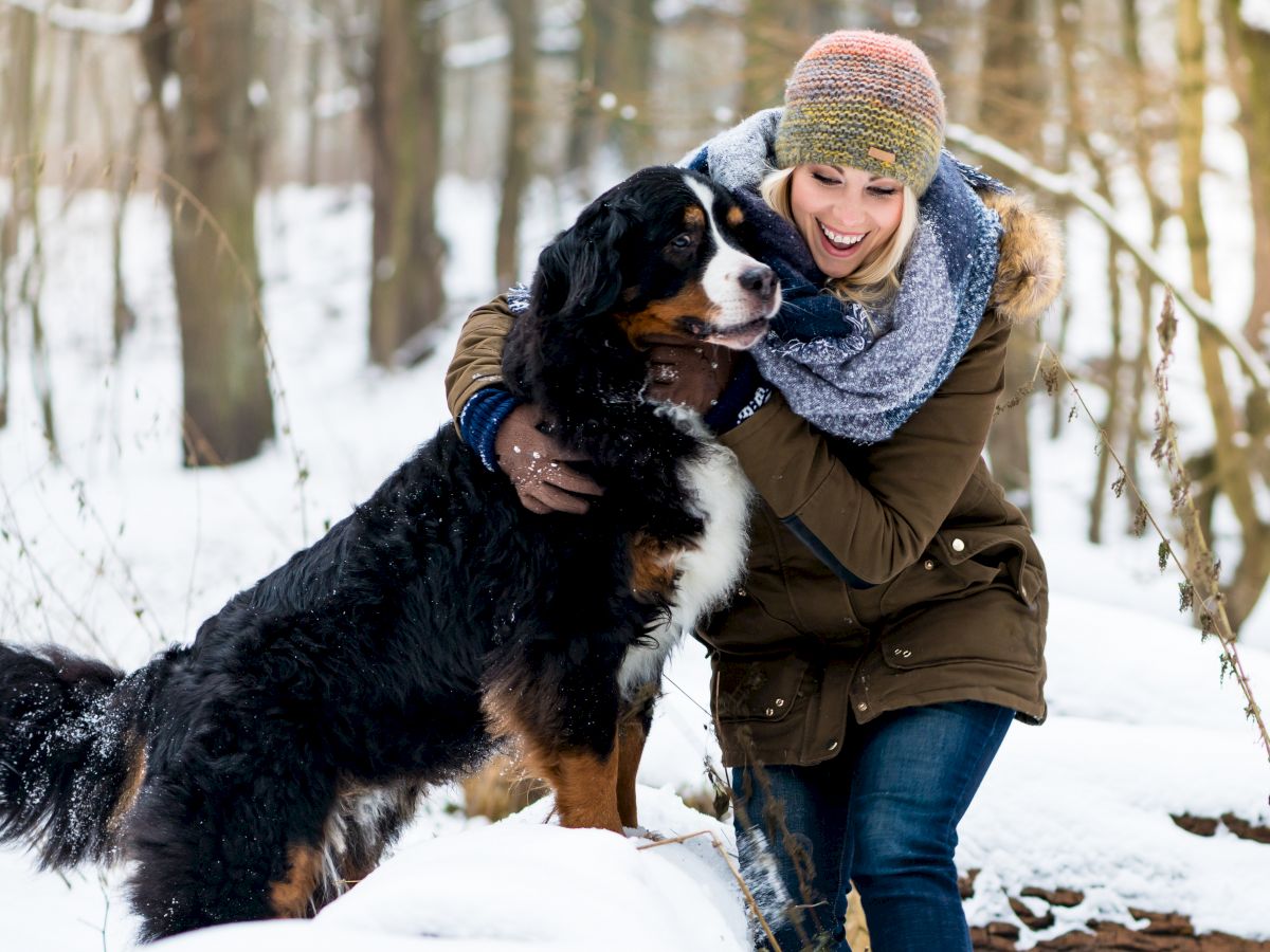 woman and dog enjoying the snow