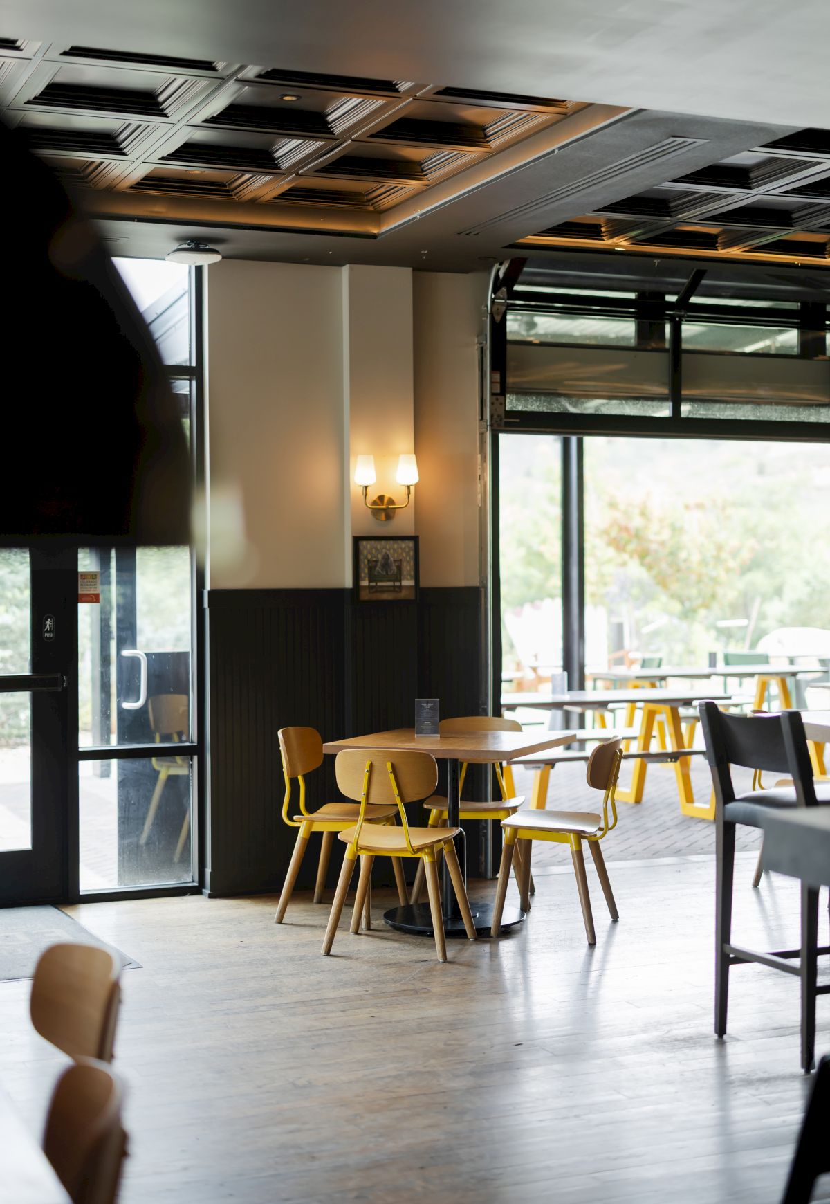 The Eddy Taproom interior with table and chairs and open garage door in Golden Colorado