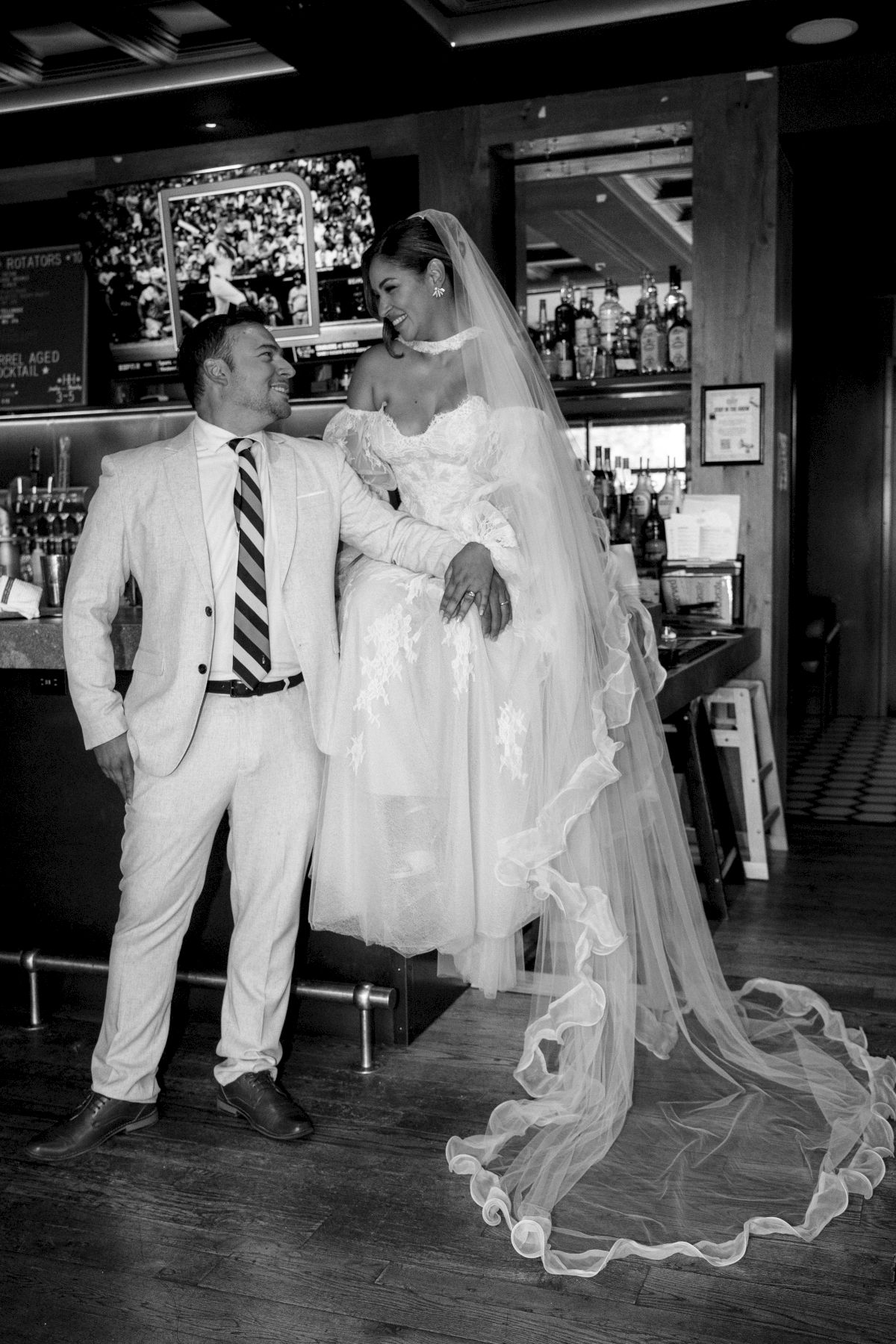 A groom in a suit smiles with a bride in a lace dress at The Eddy Taproom & Hotel in Golden Colorado