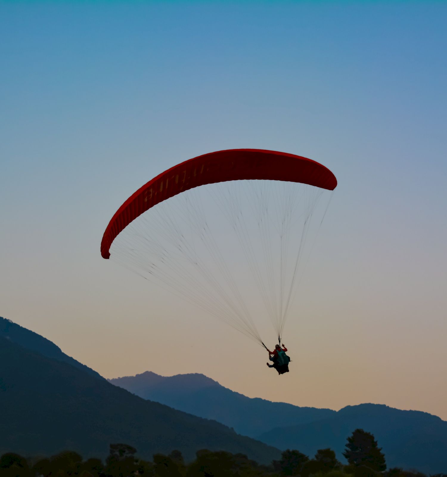 person paragliding over mountains