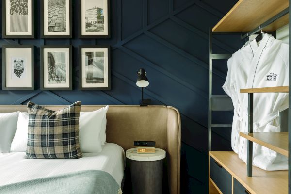 Bed with side table and a robe hanging